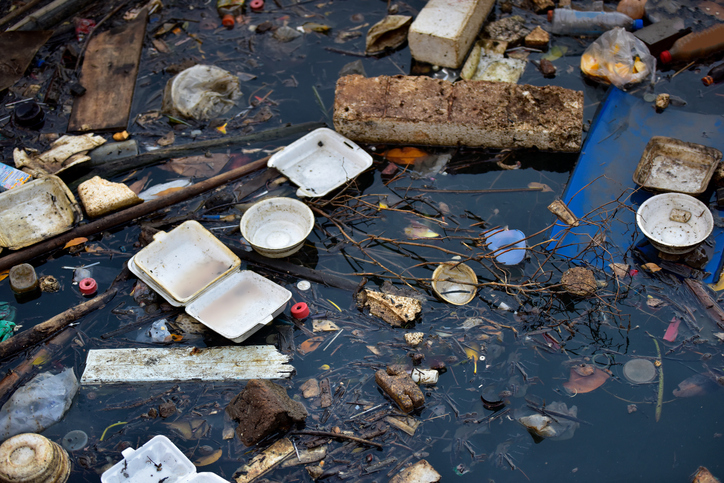 Beach pollution. Plastic bottles and other trash on river .