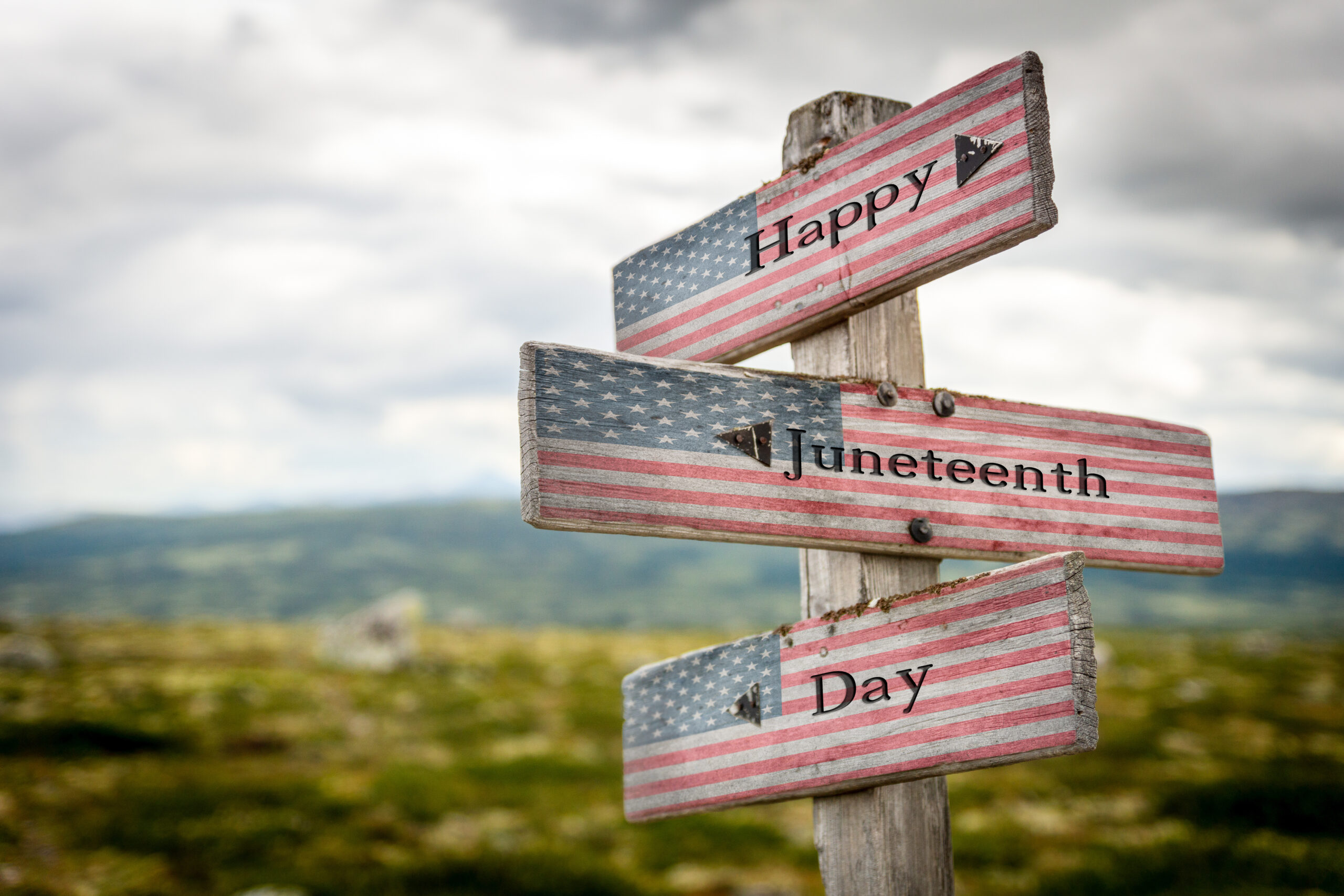 Happy juneteenth day text on wooden american flag signpost
