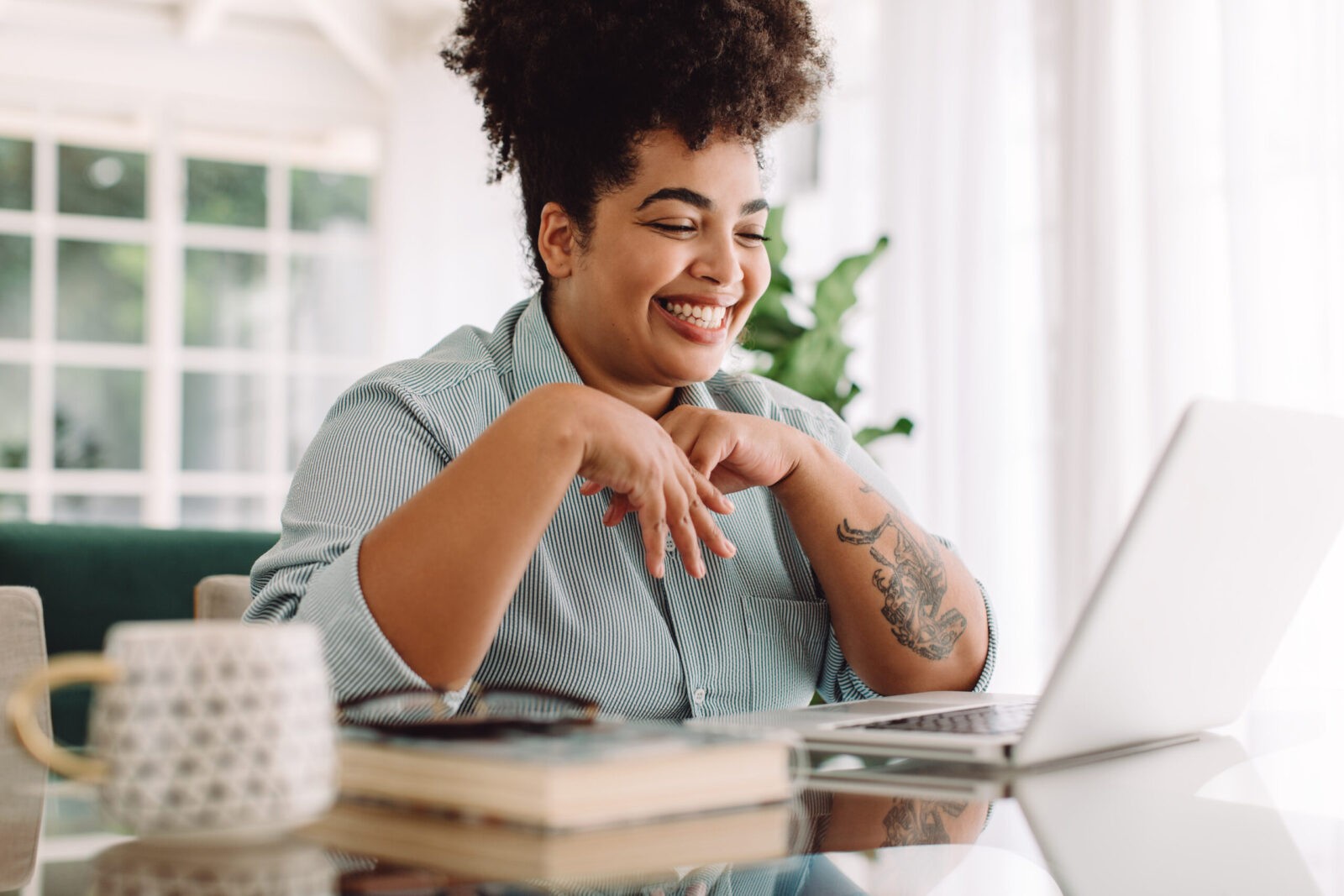 Positive woman video calling using laptop. Businesswoman teleconferencing on laptop while working from home.