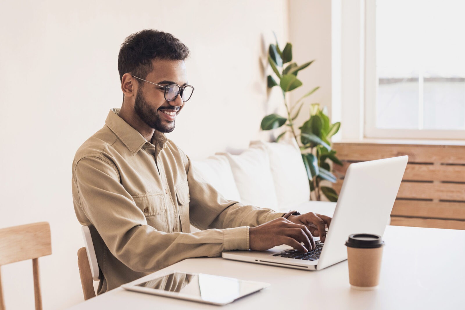 Man with glasses working from home on laptop