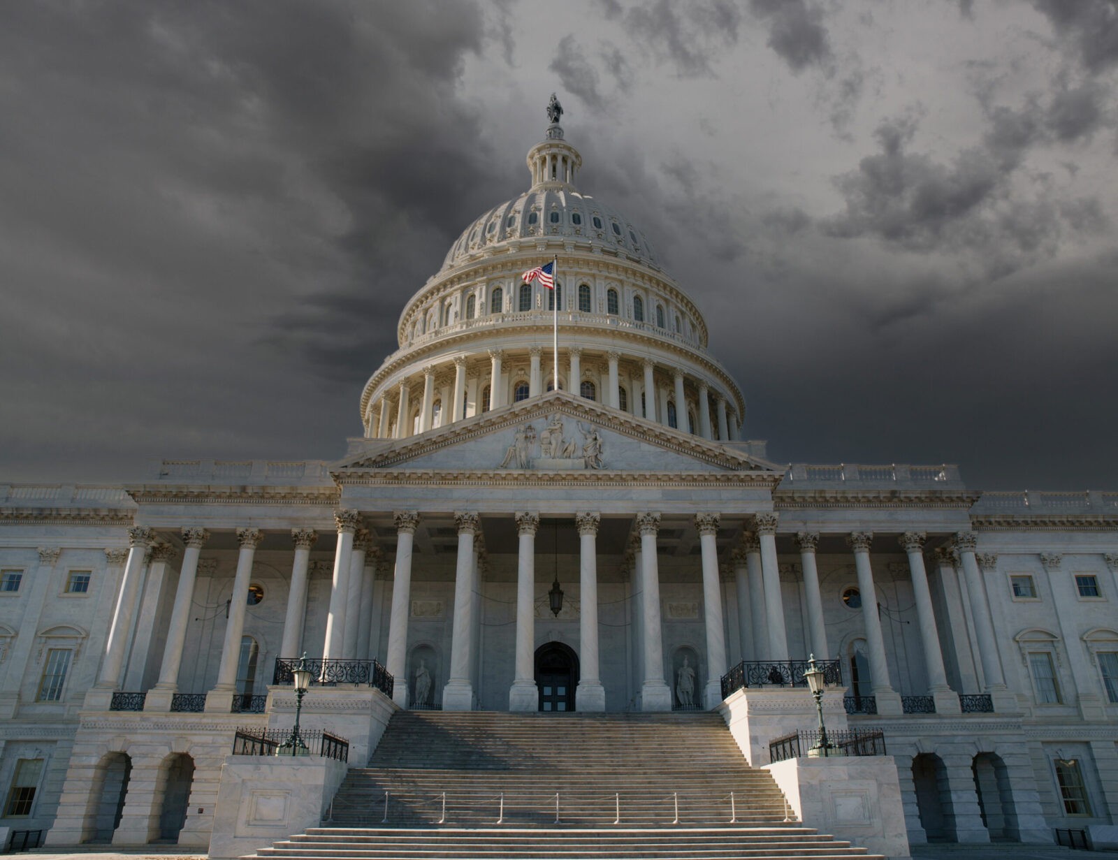 United States Capitol Building in Washington DC with dark thunderstorm sky.