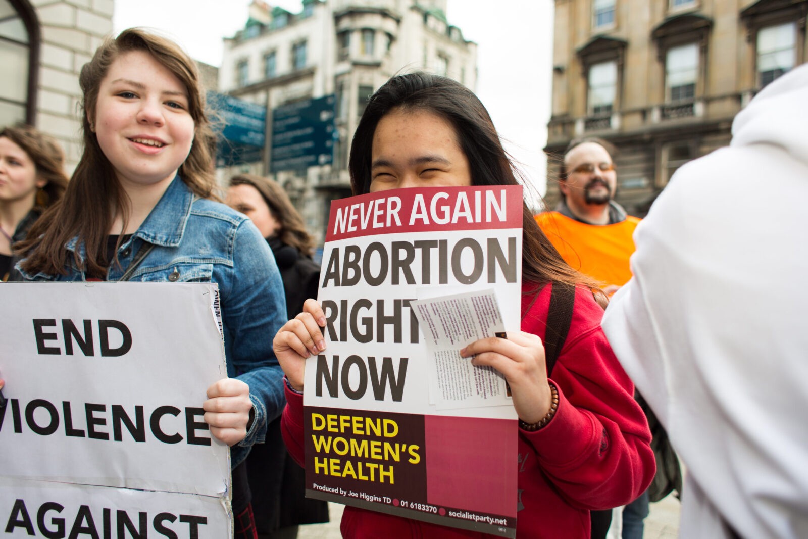 Young girl hiding behind the poster regarding abortion rights