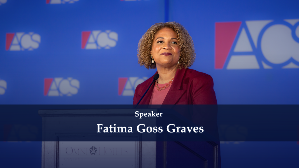 Fatima Goss Graves speaking at a podium on a stage with a blue backdrop and event logos behind her.